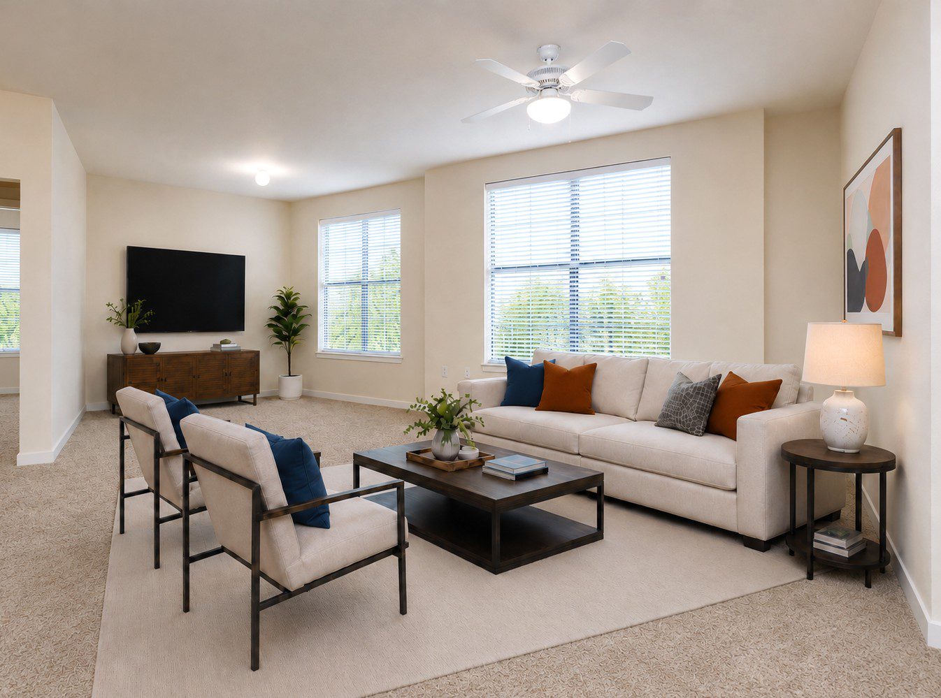 large living room with large windows and carpet and contemporary furniture with neutrals, blues, and oranges matching artwork
